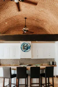 Kitchen area with four chairs, ceiling fan, and a painting