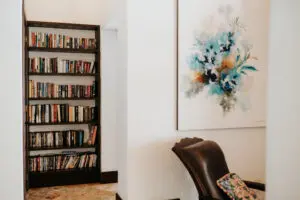 bookshelf, painting, and a chair