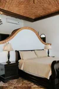 a bed with two pillows and side lamps