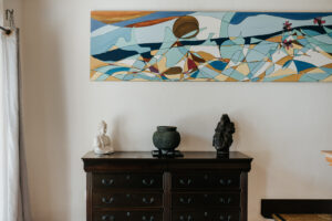 painting above a table with three decore items