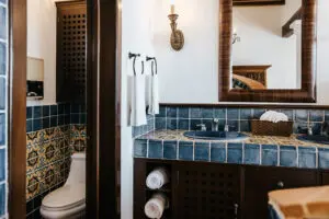 view of a washroom with commode and two sinks