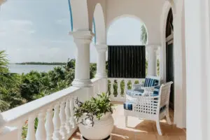 a balcony in a villa with two chairs and a plant