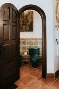 a washroom entrance door and a green commode