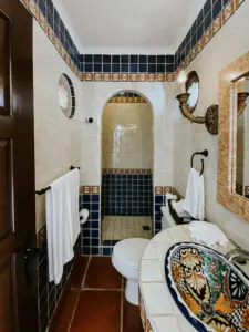 a washroom with sink, towels, and commode