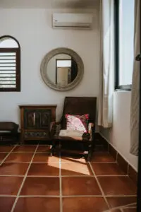 a relaxing chair, side table, and a round mirror